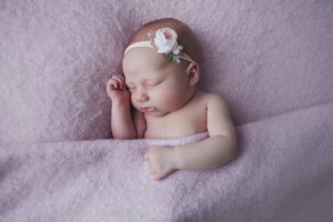 newborn baby photo headband pose bed pink