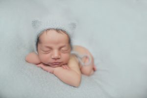 newborn baby photography bear hat blue curled up face forward posed