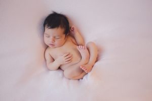 newborn baby curled up blush pink pose