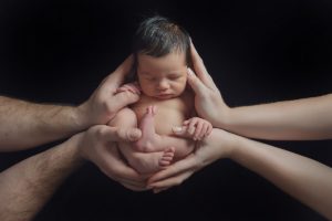 curled up black in mum dad parents hands